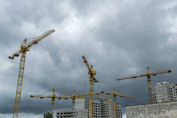 Construction cranes under the stormy sky